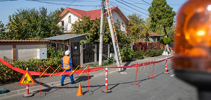 Angajat Rețele Electrice care se uită în sus, la o linie electrică aeriană